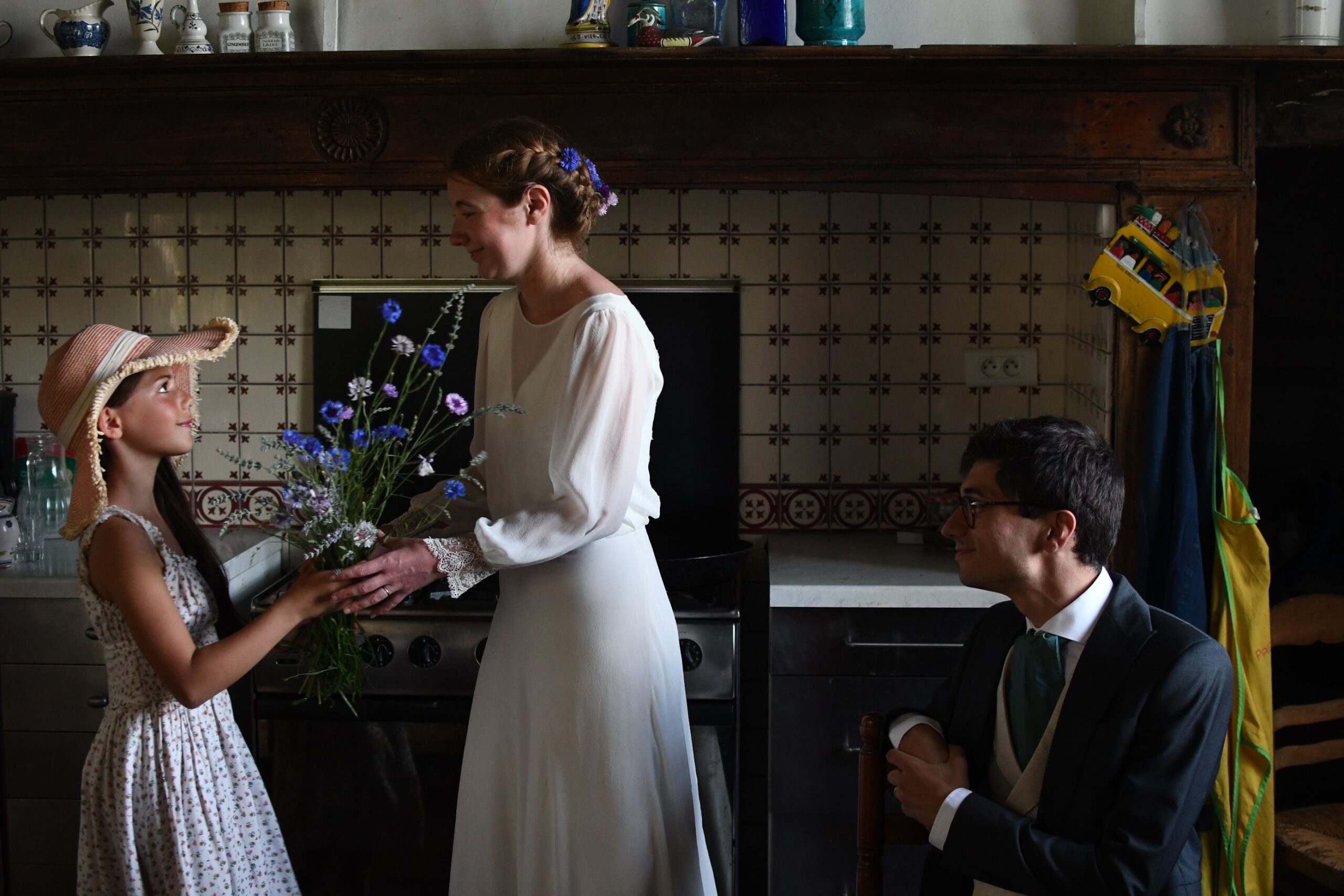 Fillette offrant un bouquet de bleuets à la mariée dans la cuisine du Château de Lihus
