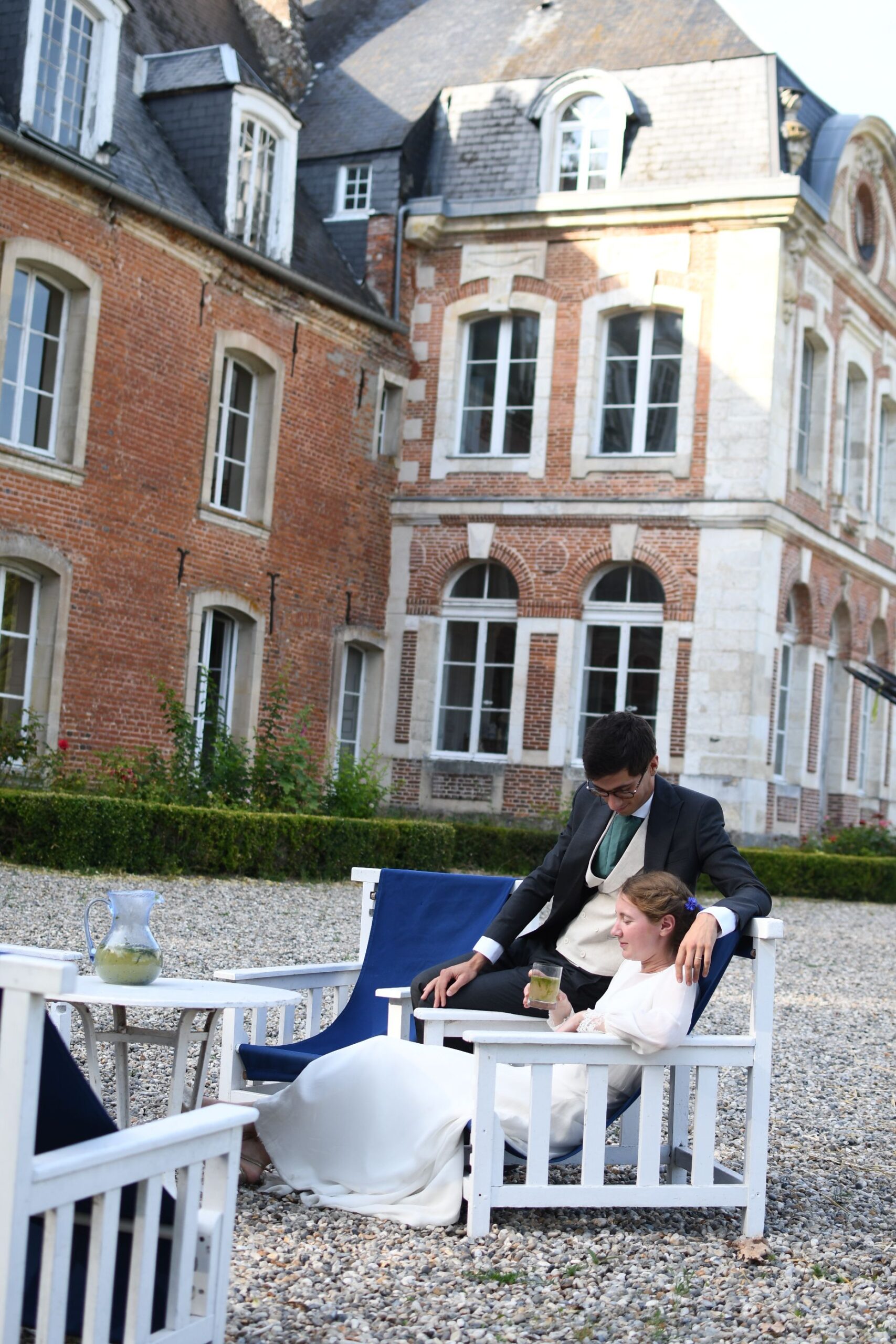 Mariés sur les fauteuils de la cour devant la façade en brique du Château de Lihus